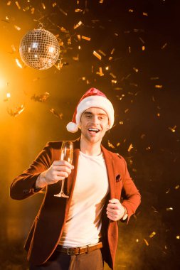 mutlu genç adam düşen konfeti kutlama Noel şampanya ile