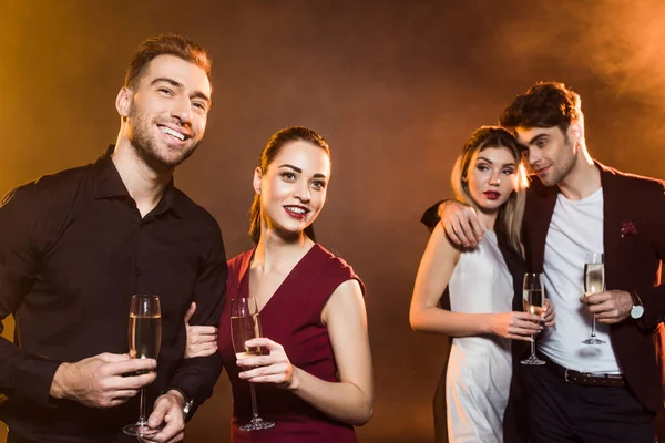 Счастливые Молодые Пары Бокалами Шампанского Стоящие Золотым Светом Время Вечеринки — стоковое фото