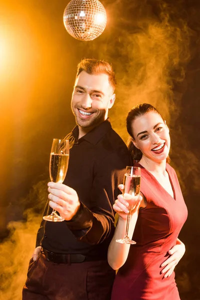 Lyckligt Par Grillas Med Glas Champagne Medan Tittar Kameran Gyllene — Gratis stockfoto