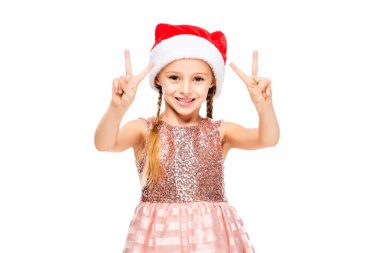 Noel Baba şapkası beyaz izole kamera barış belirtileri gösteren sevimli küçük çocuk