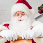 Père Noël claus tenant parchemin avec wishlist