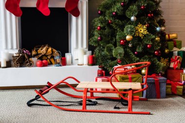 Kızak ve hediye kutuları şömine yakın ile Noel ağacı