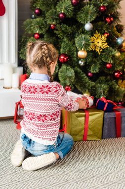 arkadan görünüşü sevimli çocuk Noel ağacının altında hediye kutuları açma