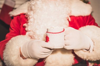Claus santa fincan sıcak içecek ve marshmallow ile tutarak atış kırpılmış