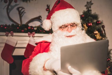 ciddi santa claus dizüstü şömine yakın kullanma