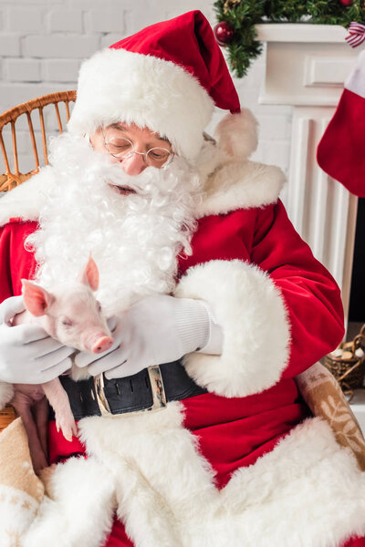 high angle view of santa claus holding pig and sitting in rocking chair