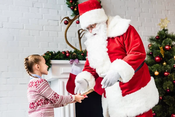 Adorable Little Child Giving Rolled Wishlist Santa Claus — Free Stock Photo