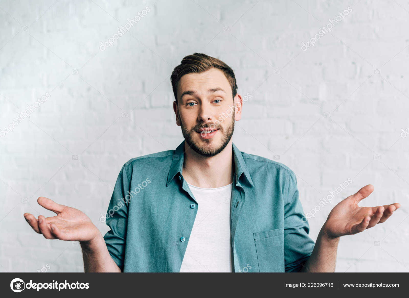 Young Man Looking Camera Doing Shrug Gesture Front Brick Wall Free Stock Photo C Igorvetushko 226096716
