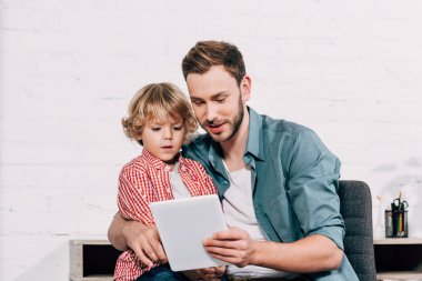 mutlu bir adam gösteren dijital tablet küçük oğul evde