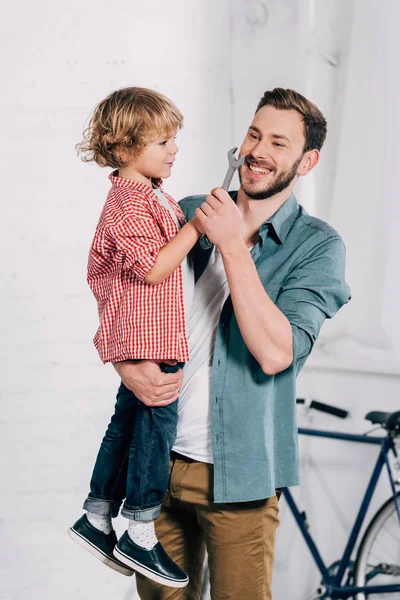 Riendo Hombre Sosteniendo Hijo Con Llave Mano Taller — Foto de stock gratis