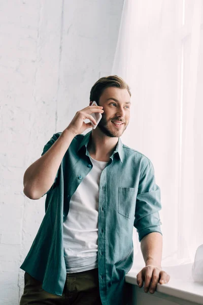 Cheerful Handsome Man Talking Smartphone Looking Away Home — Stock Photo, Image