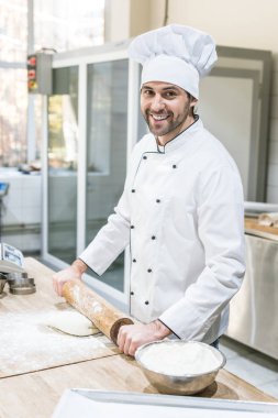 Güleryüzlü ve profesyonel mutfak hamur yayıyoruz yakışıklı Şef