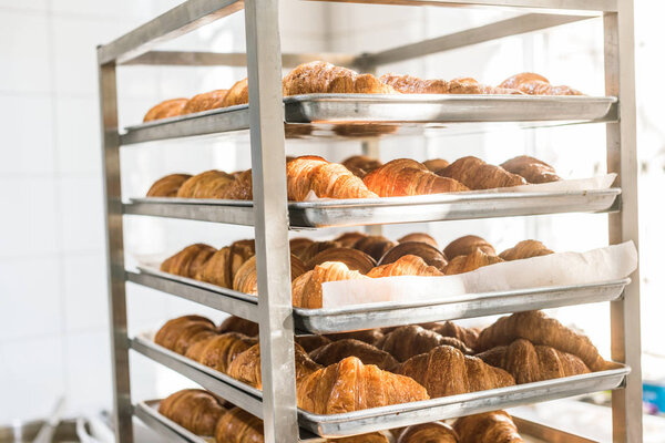 rack full of fresh tasty croissants in bakehouse 