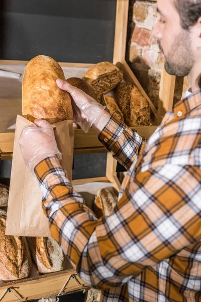 Man Putting Freshly Baked Bread Paper Bag — Free Stock Photo