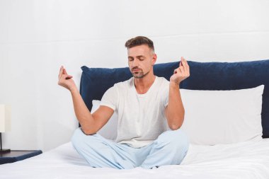 Yatak odasında Yoga pratik yakışıklı adam 