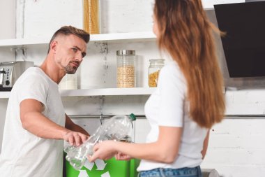 yeşil kutu geri dönüşüm işareti ile boş plastik şişe koymak çift