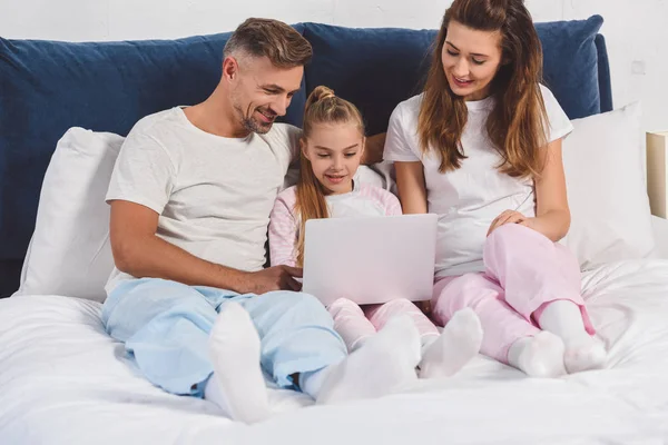 ノート パソコンでパジャマで寝室で横になっている家族  — 無料ストックフォト