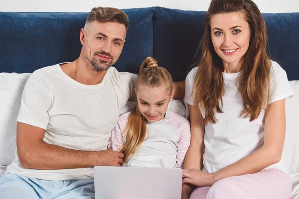 陽気な家族のラップトップでパジャマで横になっています  — 無料ストックフォト