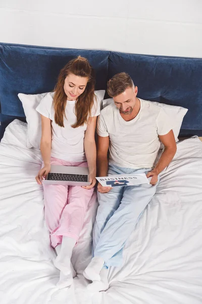 Overhead View Husband Reading Newspaper Lying Wife Bed — Free Stock Photo