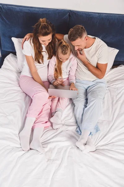 Översiktsbild Familjen Ligga Sovrummet Med Laptop — Gratis stockfoto