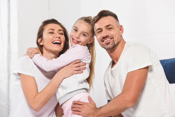 Linda Hija Abrazando Hermosa Sonriente Madre Cama Mientras Padre Mirando — Foto de Stock