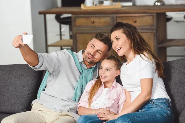 Ευτυχισμένη Οικογένεια Λαμβάνοντας Αυτοπορτρέτα Στο Smartphone Στο Σαλόνι — Δωρεάν Φωτογραφία
