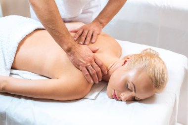 Male masseur doing massage to blonde woman  clipart