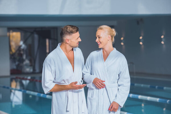 Счастливая пара, стоящая в халатах в спа
