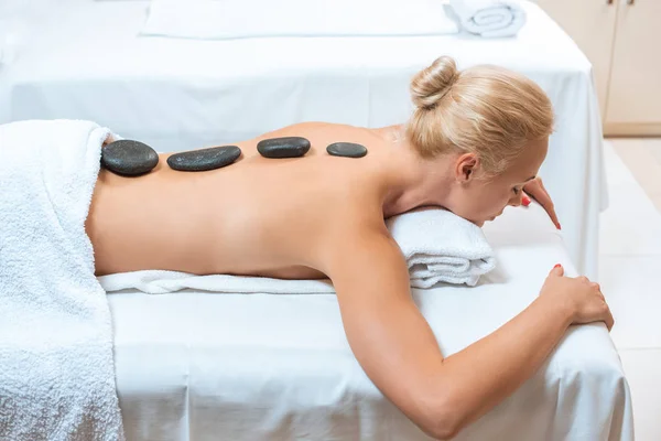Schöne Frau Liegt Mit Heißen Steinen Auf Dem Rücken Wellnessbereich — Stockfoto