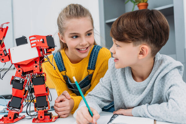 счастливые одноклассники говорят на уроке робототехники STEM
 
