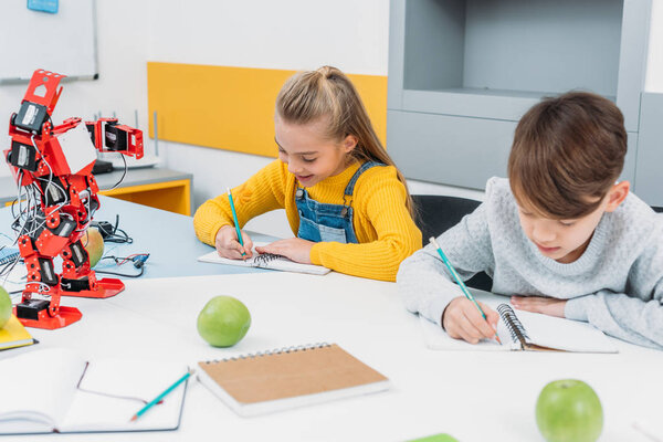 внимательные дети, пишущие на уроке робототехники STEM
