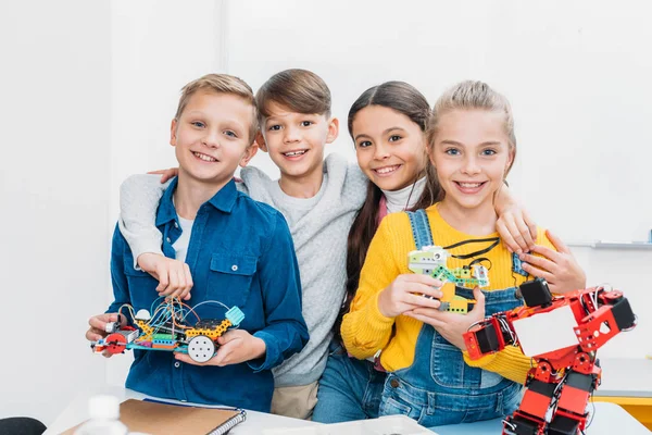 Uśmiechający Się Dzieci Wieku Szkolnym Stoi Trzymając Roboty Elektryczne Patrząc — Zdjęcie stockowe