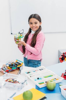 kameraya bakarak ve el yapımı robot modeli kök ders sunma güzel kız öğrenci