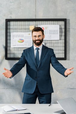 kollarını açarak ayakta ve kamera Office gülümseyen neşeli sakallı işadamı