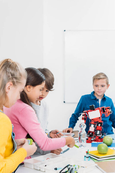 schoolchildren programming robot together during STEM educational class