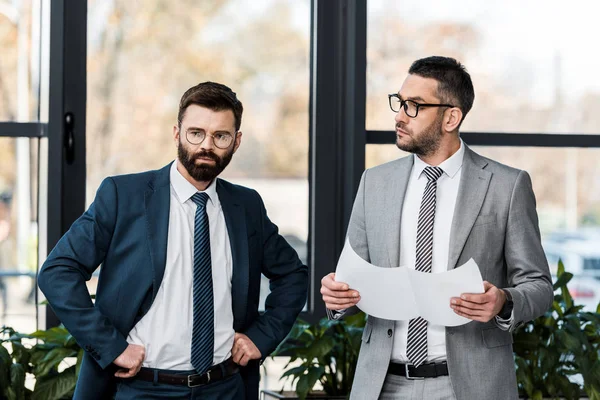 Hombres Negocios Serios Pie Juntos Discutiendo Proyecto Oficina —  Fotos de Stock