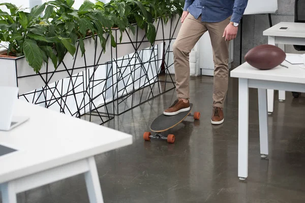 ビジネスマンのオフィスでスケート ボードの上に立っての低いセクション — ストック写真