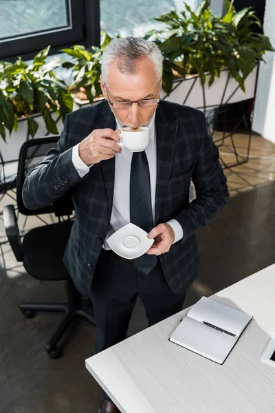 Μεγάλη Γωνία Προβολής Ώριμες Επιχειρηματία Που Πίνει Καφέ Στο Γραφείο — Δωρεάν Φωτογραφία