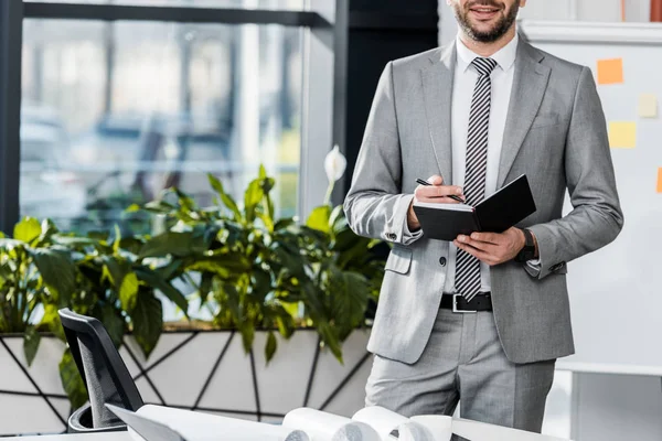 Recortado Disparo Sonriente Hombre Negocios Traje Escribir Cuaderno Lugar Trabajo — Foto de Stock