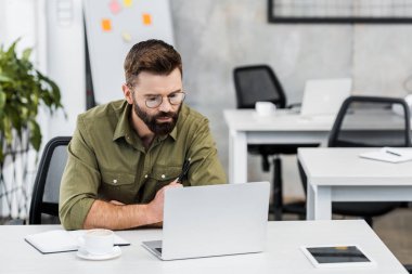 yakışıklı işadamı office içinde laptop bakarak