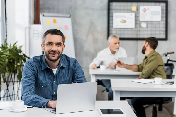 Lächelnder Gutaussehender Geschäftsmann Der Laptop Arbeitet Und Büro Die Kamera — Stockfoto