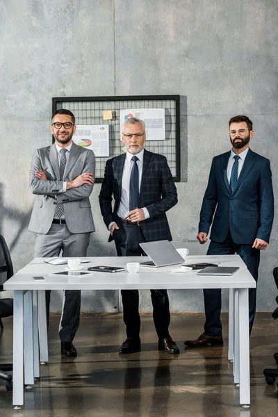 Hombres Negocios Guapos Trajes Pie Mirando Cámara Oficina — Foto de Stock