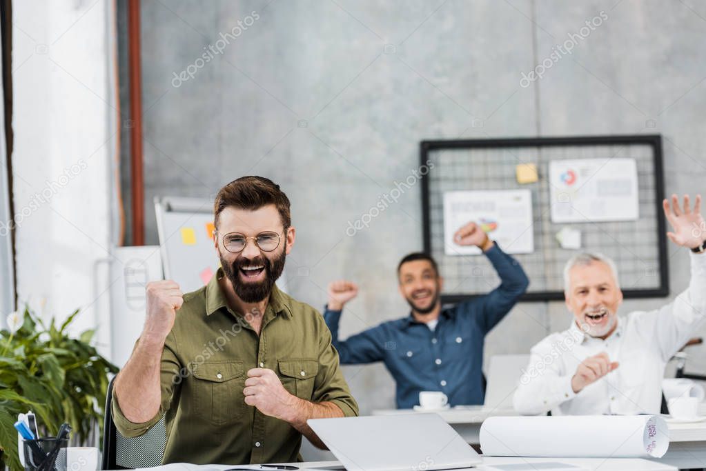happy handsome businessmen showing yes gesture in office