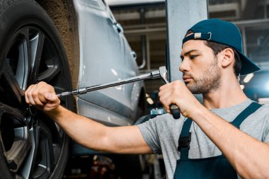 tekerlek anahtar ile genel çalışma otomatik mekanik dükkanında çalışan erkek otomatik mekanik odaklı