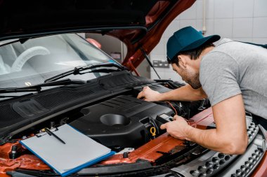 otomatik mekanik araba pil voltajı mekanik dükkanında kontrol multimetre Voltmetre ile