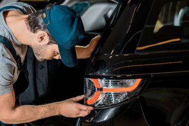 Genç otomatik mekanik kontrol araba arka far oto tamircisi, yan görünüm