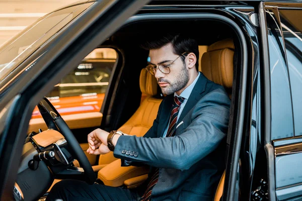 Stilvoller Geschäftsmann Mit Brille Checkt Uhr Luxusauto — Stockfoto