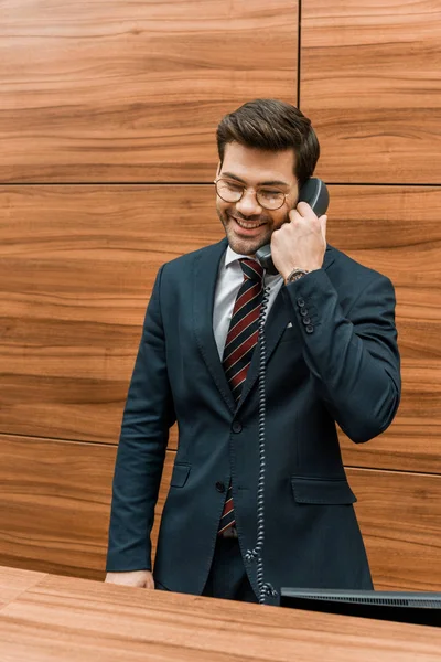 Tersenyum Pengusaha Dalam Kacamata Berbicara Telepon Stasioner Penerimaan Kantor Modern — Stok Foto