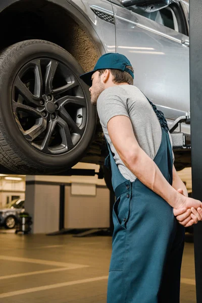 Zadní Pohled Mužské Automechanika Práci Celkovou Kontrolu Kola Automobilu Opravně — Stock fotografie