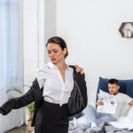 Дівчина в куртці і хлопець у піжамі читає газету в спальні вранці вдень, концепція гендерної рівності